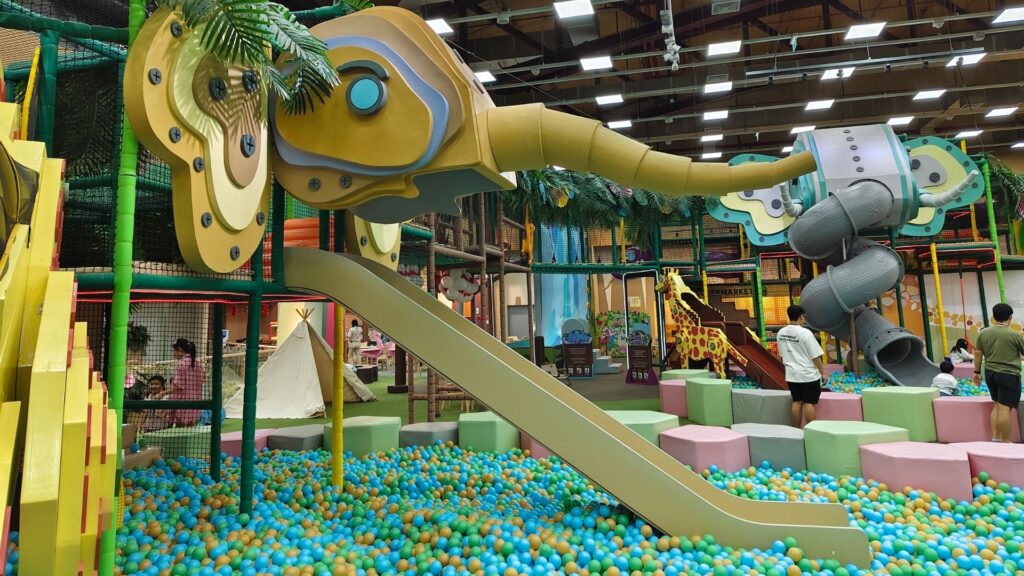A colorful indoor playground, with slides that look like elephants.