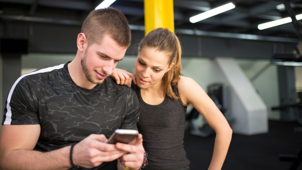 Two people reading an email promotion from their favorite gym, before their next class starts.