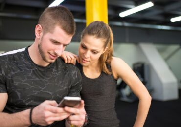 Two people reading an email promotion from their favorite gym, before their next class starts.