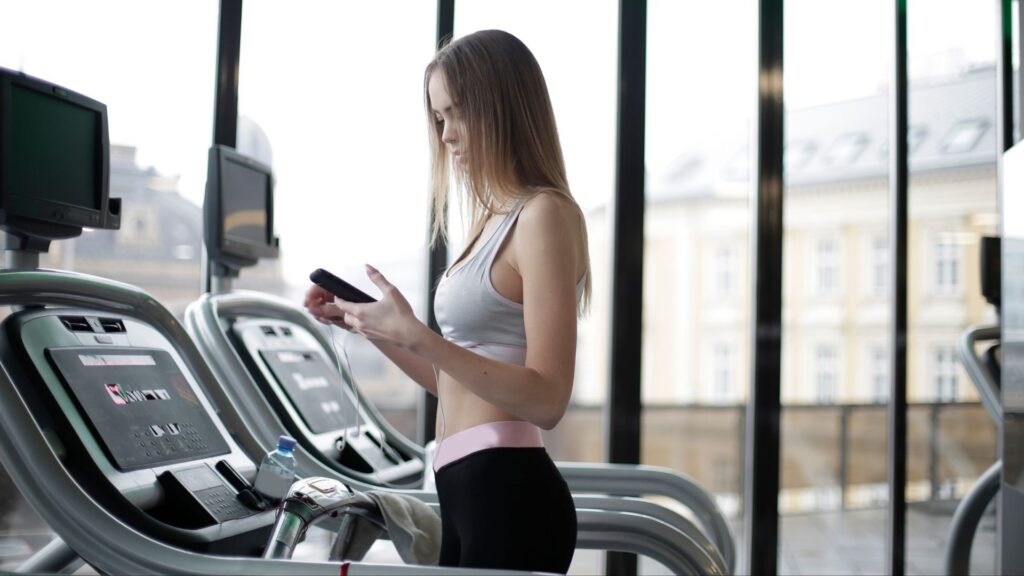 A woman receiving a text message promotion while on the treadmill at her gym.