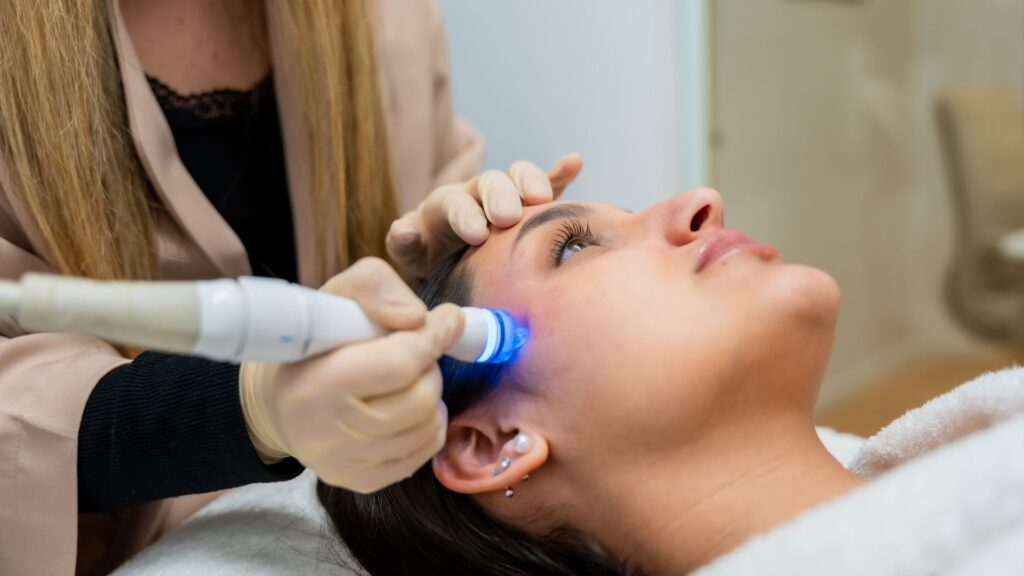 A woman getting a laser treatment at her favorite spa, run by WellnessLiving.