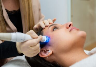 A woman getting a laser treatment at her favorite spa, run by WellnessLiving.