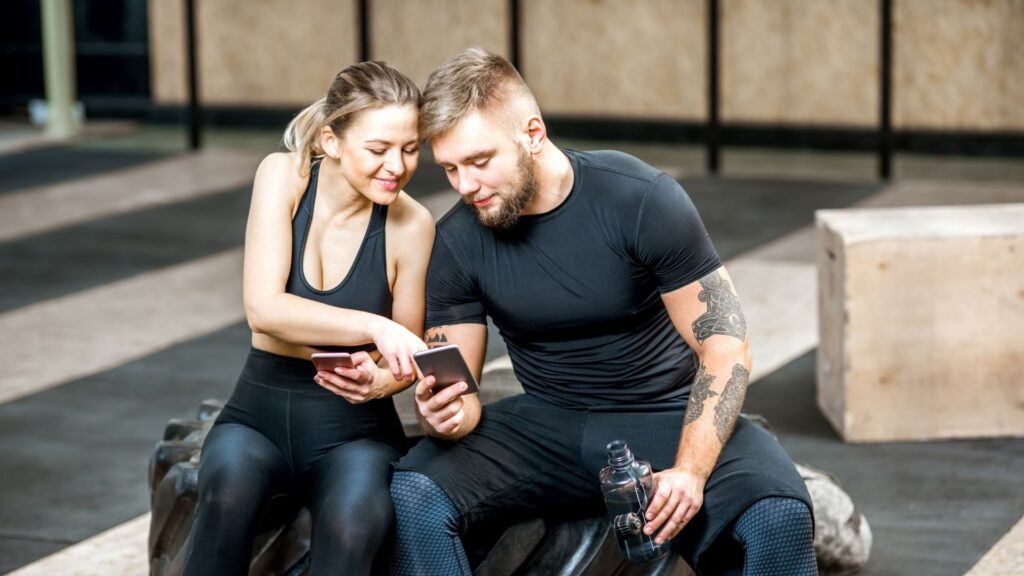 Two people booking their next fitness class on one of WellnessLiving's white-label gym apps.