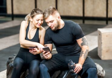 Two people booking their next fitness class on one of WellnessLiving's white-label gym apps.