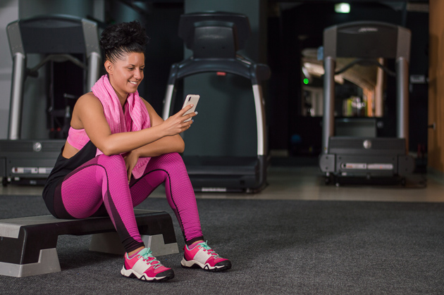 woman at gym looking at phone 