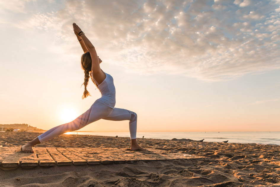 yoga trends, girl doing yoga on the beach