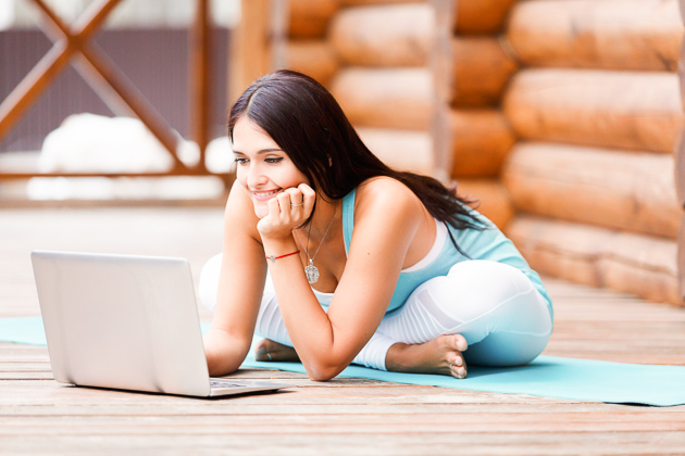 Yoga studio promotion, woman checking her email while doing yoga