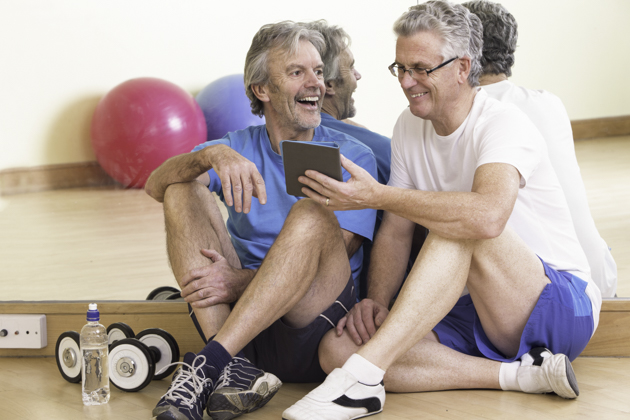 social media to market your gym, mature men on tablet
