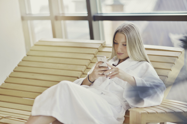 wellness center marketing, woman in spa with phone