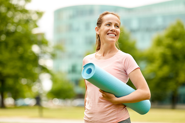 stay motivated as a Pilates studio owner, happy woman with yoga mat